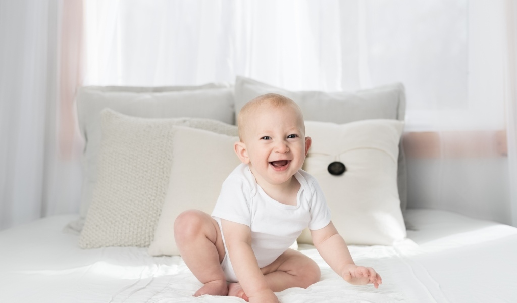 Смешной маленький ребенок на кровати