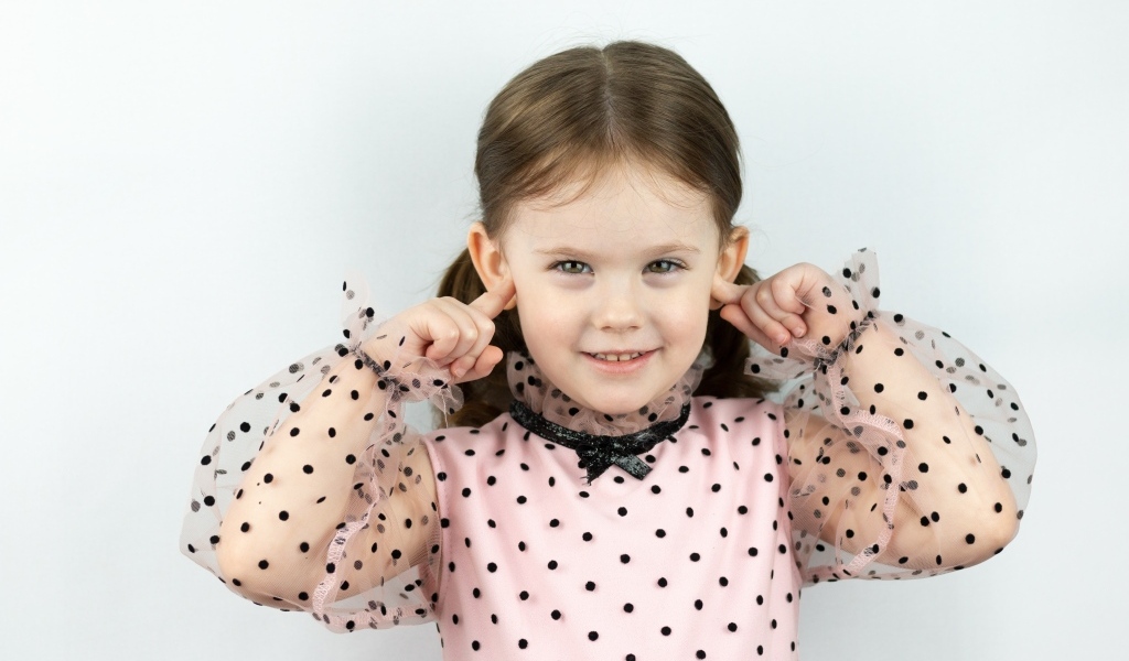 Смешная маленькая девочка закрыла уши