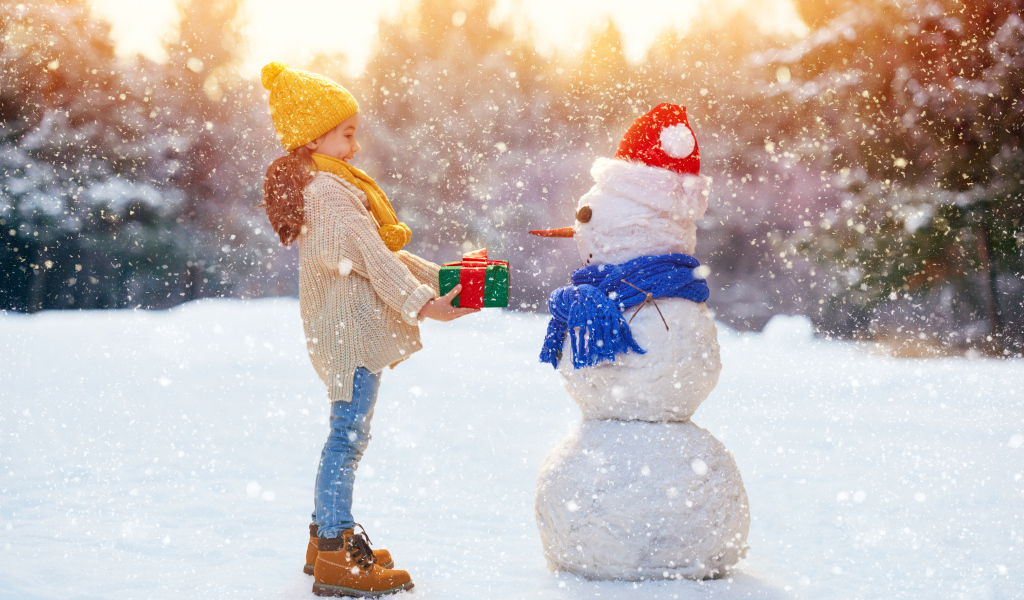 Девочка дарит подарок снеговику