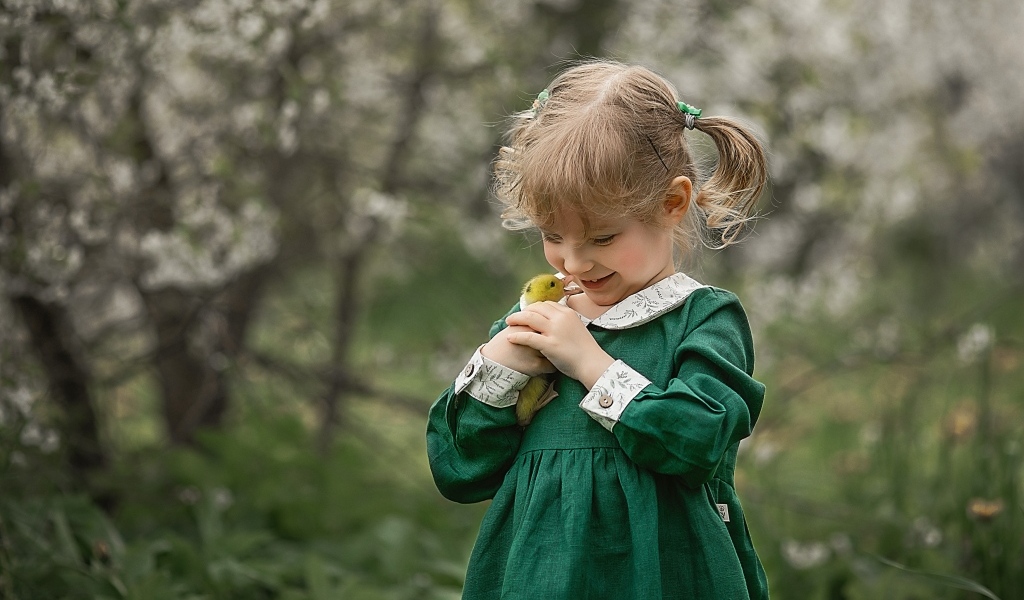 Девочка в зеленом платье с утенком в руках