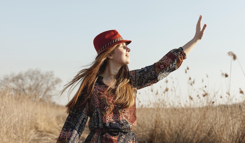 Девочка в шляпе на поле в лучах солнца