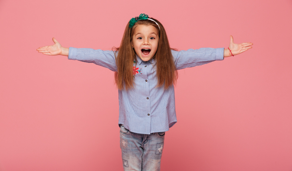 Счастливая маленькая девочка на розовом фоне