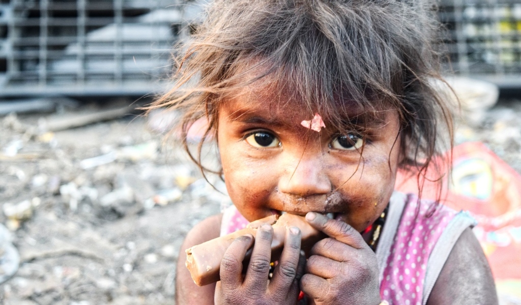 Маленькая азиатская девочка с конфетой в руках