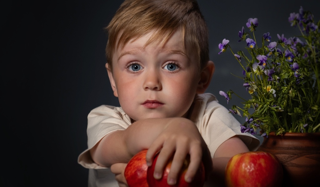 Маленький голубоглазый мальчик с яблоками