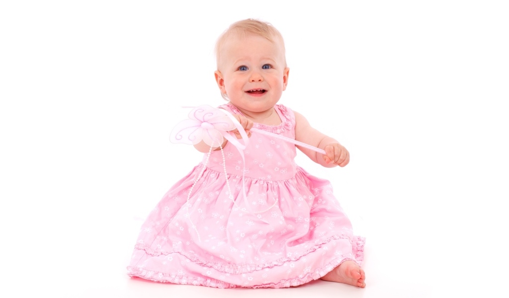 Маленькая девочка в розовом платье на белом фоне