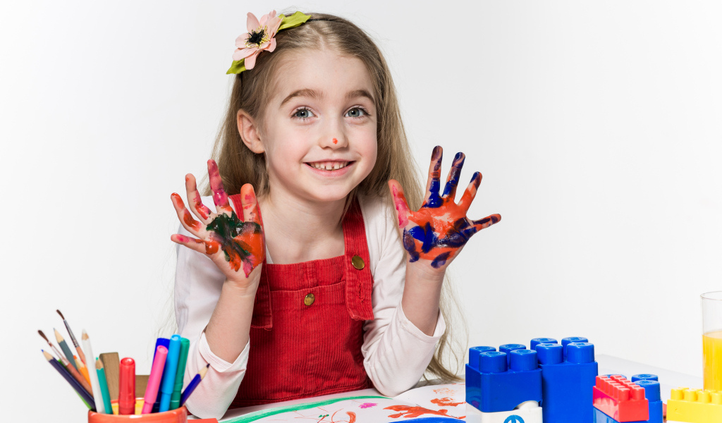 Маленькая девочка рисует красками