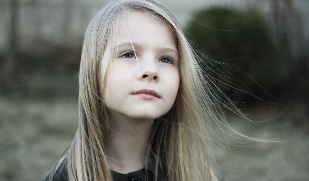Задумчивая маленькая девочка с длинными волосами