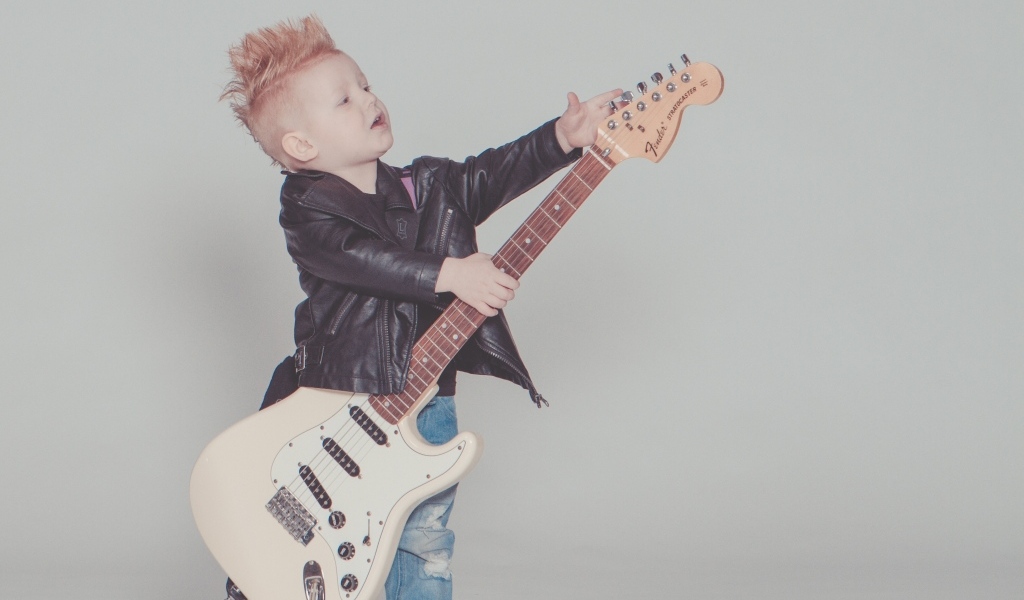 Мальчик рокер с гитарой на сером фоне