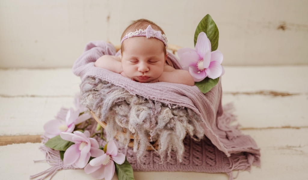 Спящая новорожденная малышка с цветами