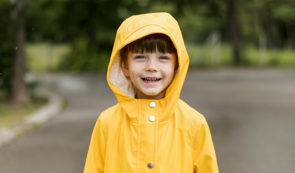 Улыбающийся мальчик в желтой куртке