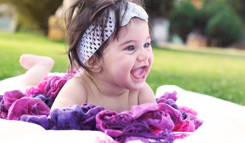 Улыбающаяся маленькая девочка с повязкой на голове 