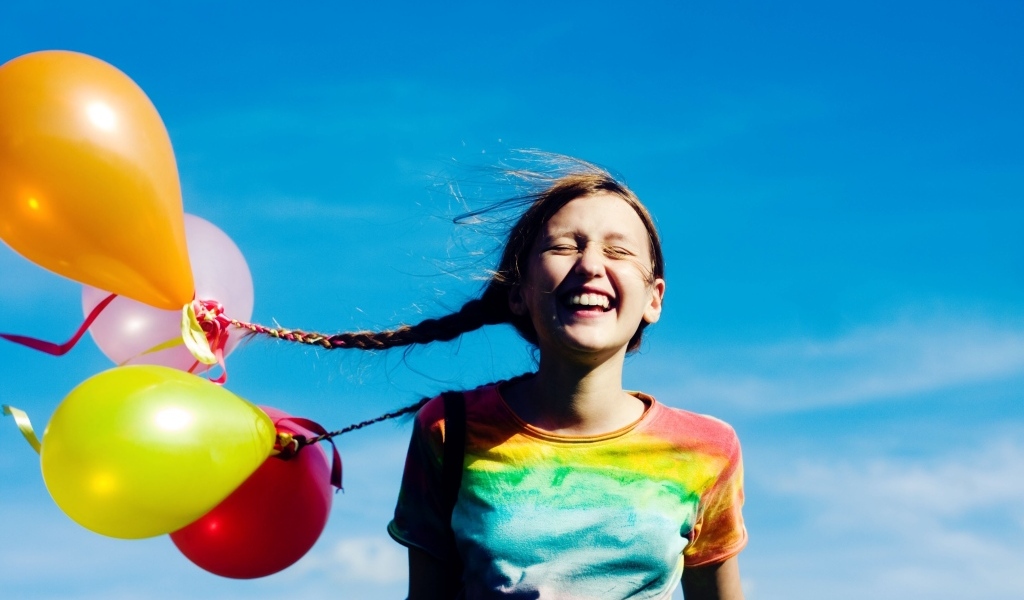 У веселой девочки шарики привязаны к косам