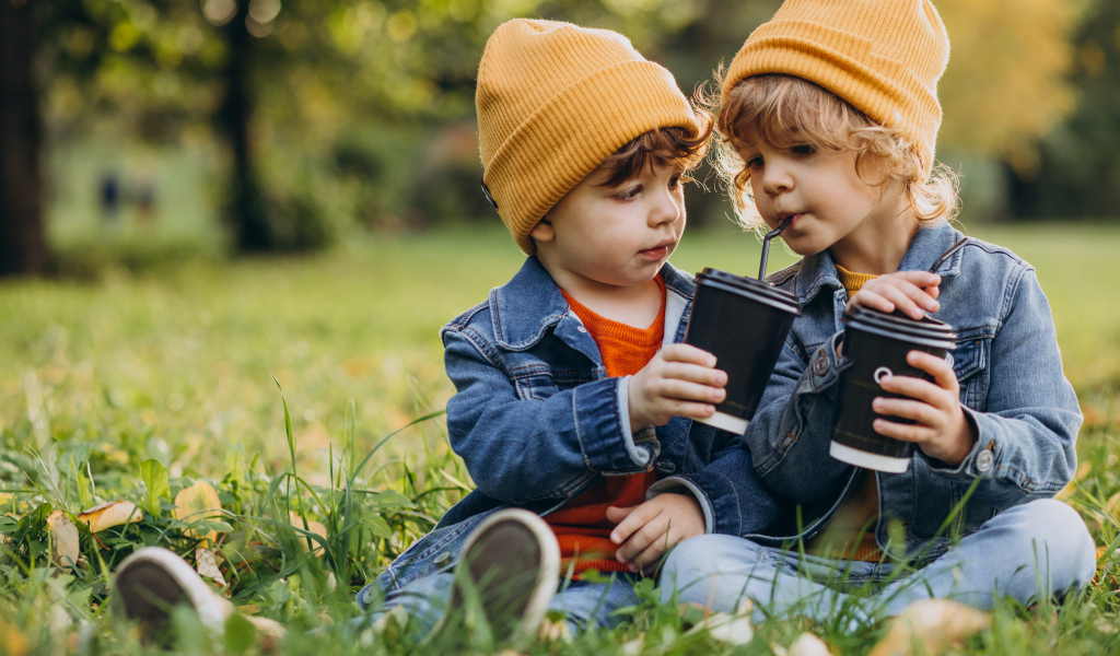 Два маленьких  брата сидят на траве