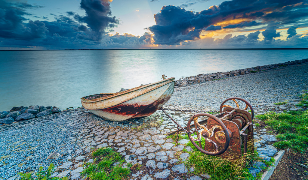 Старая лодка на берегу моря 