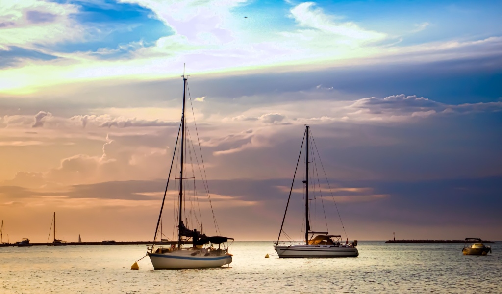 Две парусные яхты в море на закате