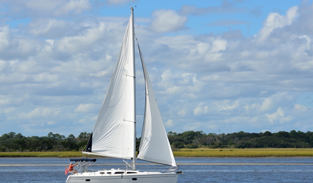 Яхта с белыми парусами на реке