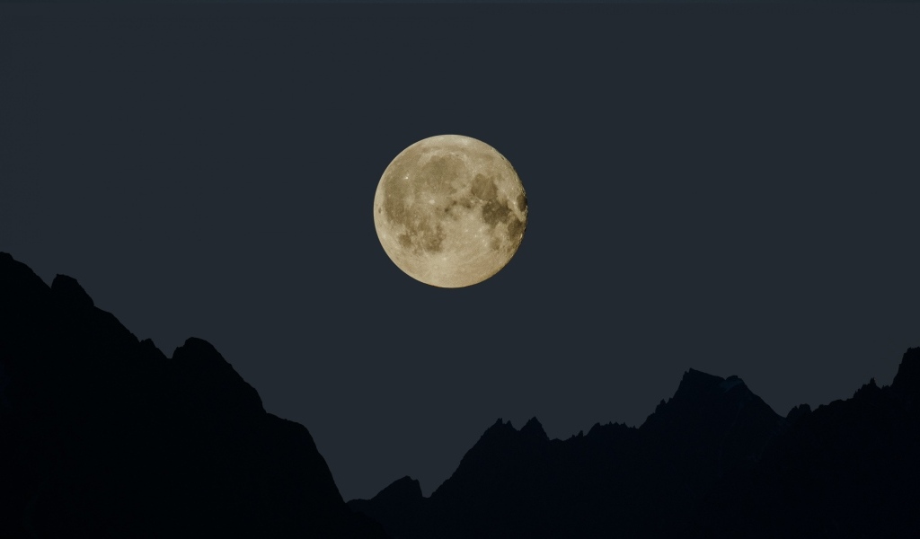 Большая белая луна над горами ночью 