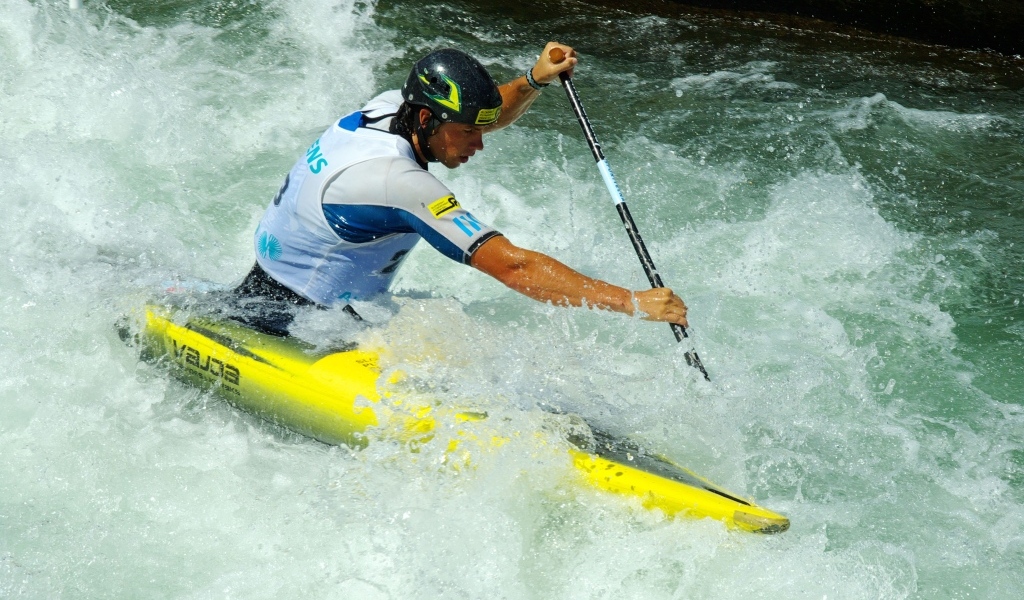 Мужчина на байдарке спускается по бурной реке