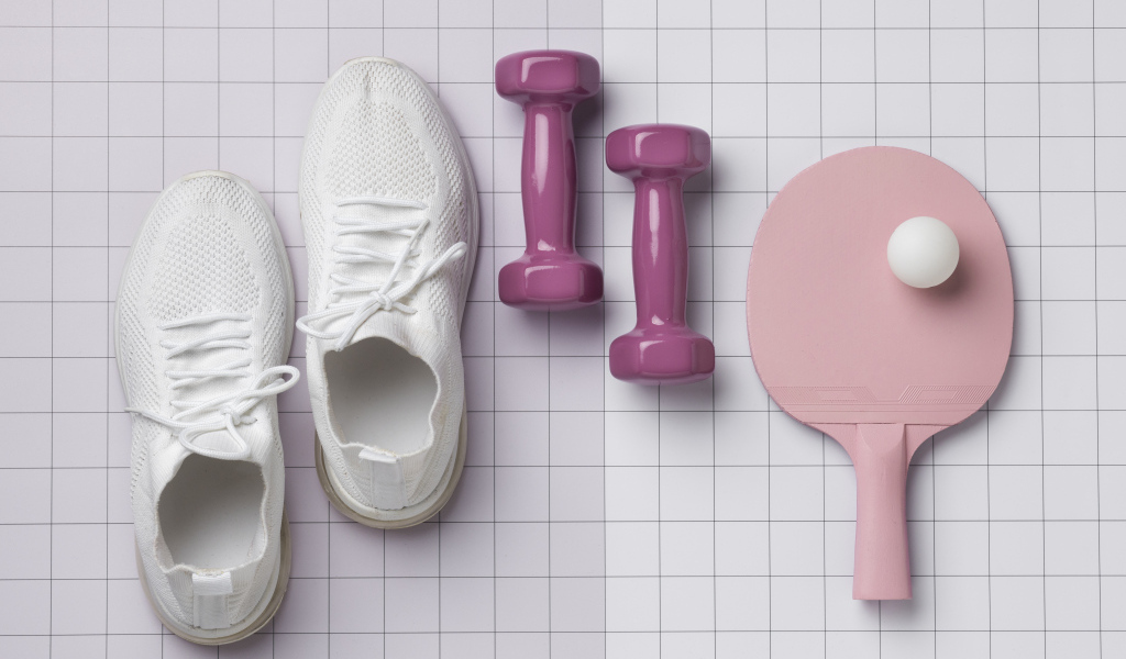 Гантели, ракетка с мячом и кроссовки на клетчатом фоне