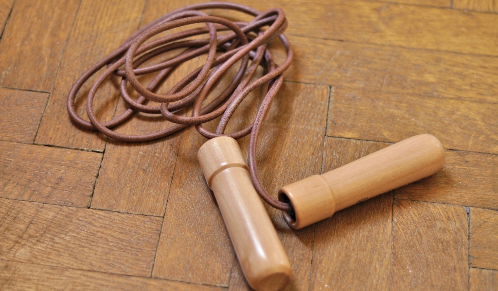 Скакалка лежит на деревянном полу