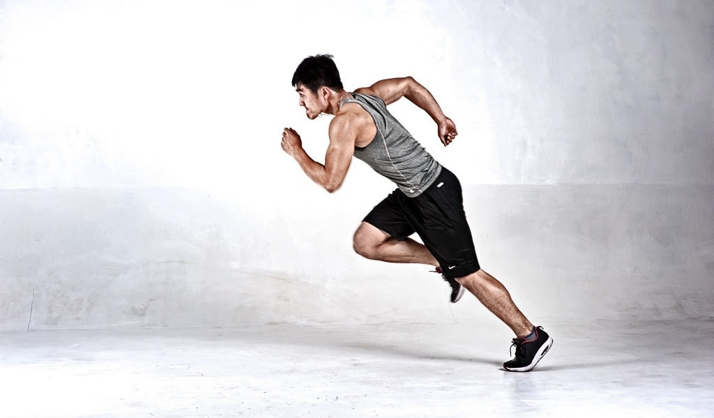 Мужчина бегун на сером фоне