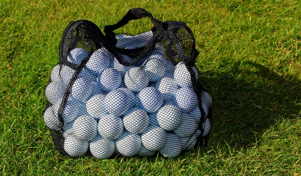 Сетка с мячами для гольфа на траве