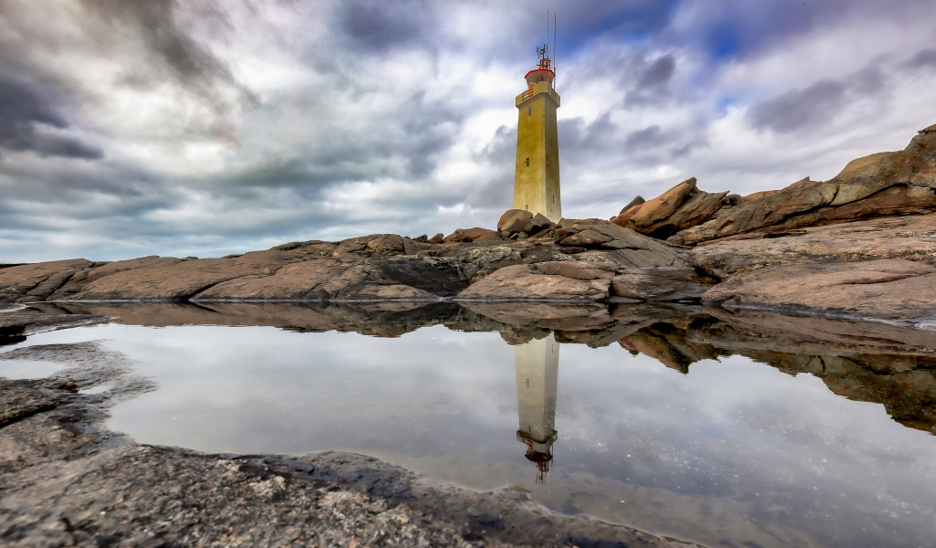 Маяк на больших камнях на берегу, Исландия