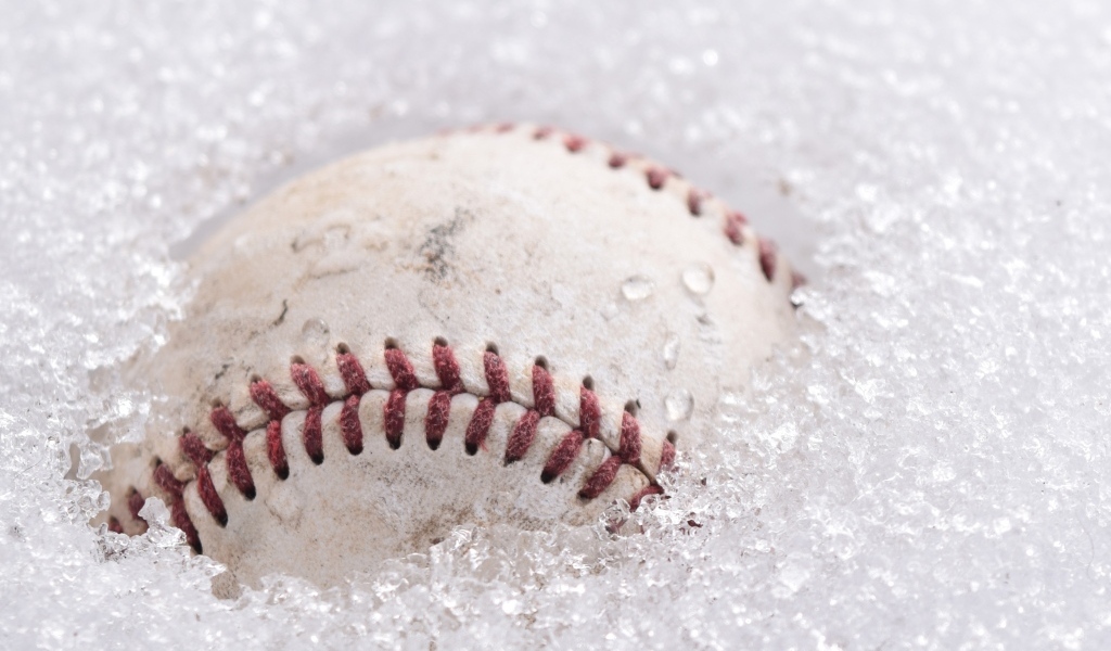 Бейсбольный мяч лежит в белом снегу
