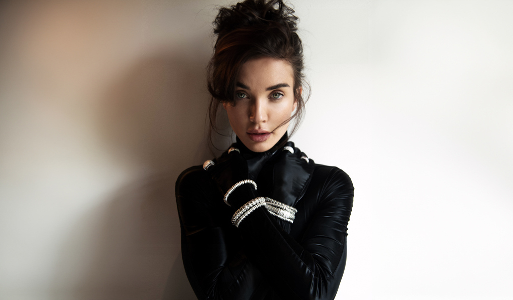 Актриса Эми Джексон стоит у стены