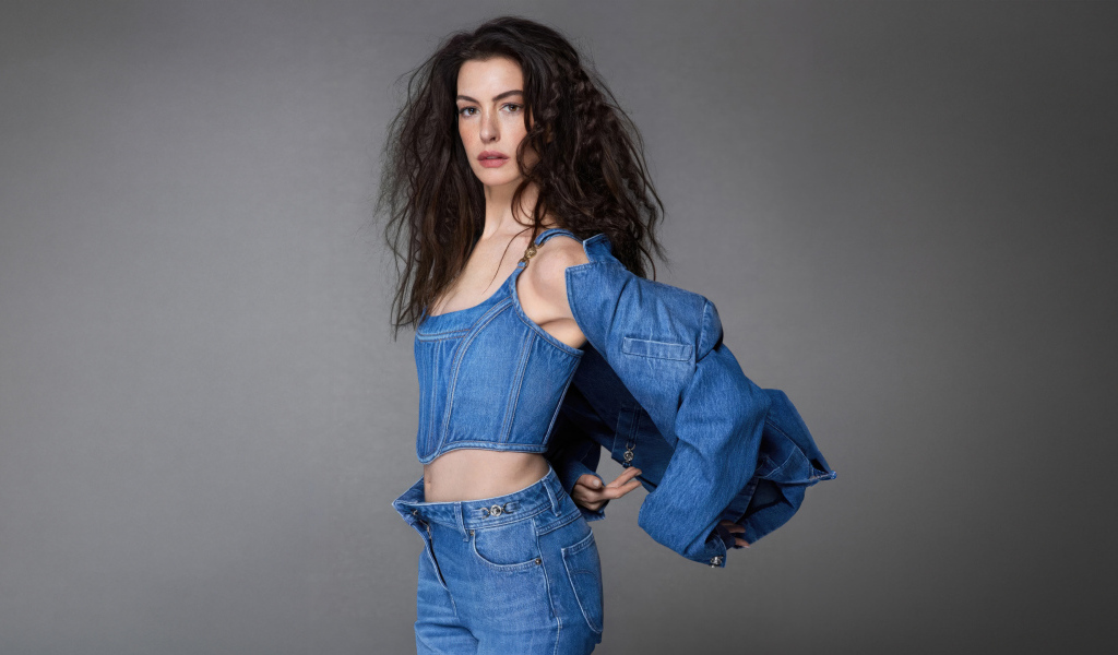 Актриса Энн Хэтэуэй в джинсовом костюме на сером фоне