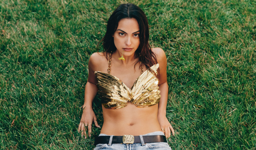 Актриса Камила Мендес лежит на зеленой траве