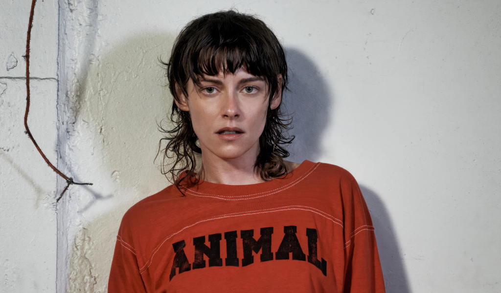 Актриса Кристен Стюарт стоит у серой стены