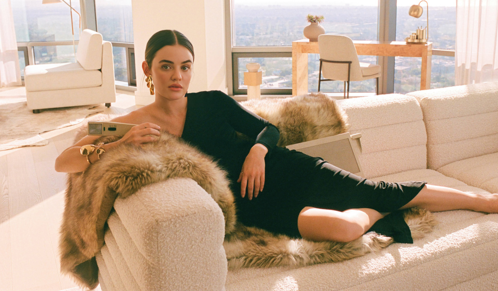 Актриса Люси Хейл в черном платье лежит на диване