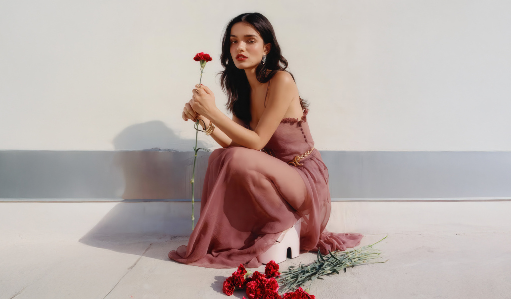 Актриса Рэйчел Зеглер с красными гвоздиками сидит на полу