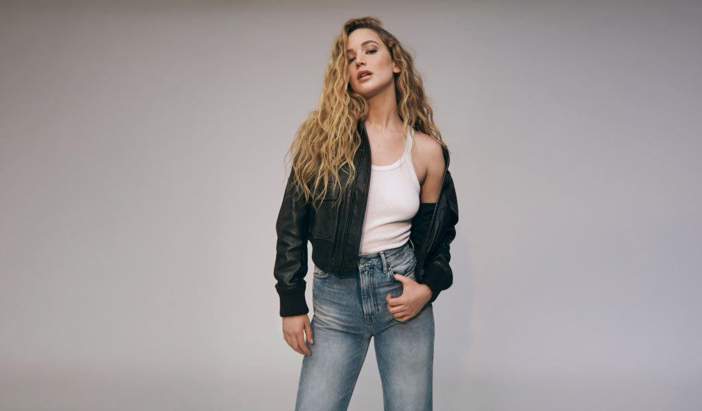 Американская актриса Дженнифер Лоуренс  в джинсах на сером фоне