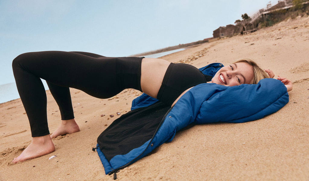 Американская актриса Сидни Суини лежит на песке