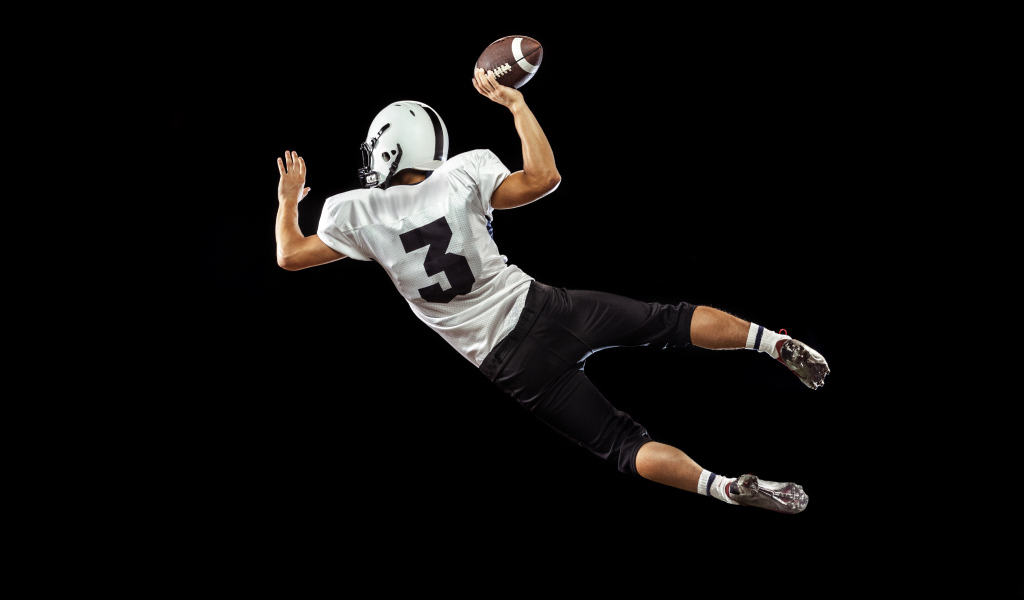 Игрок в американский футбол на черном фоне