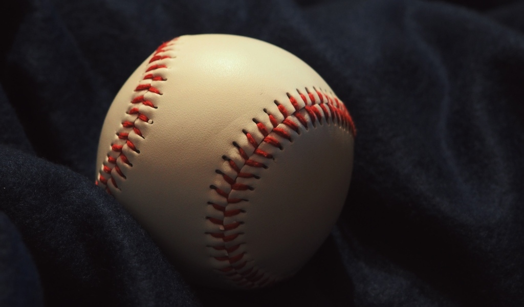 Бейсбольный мяч на черной ткани 