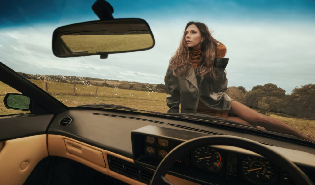 Красивая Виктория Бекхэм сидит на машине