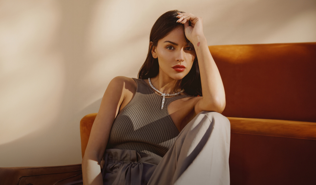 Красивая брюнетка, актриса Эйса Гонсалес сидит у дивана