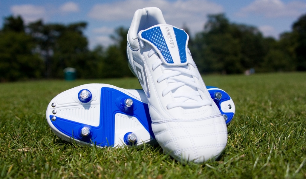 Красивые новые футбольные бутсы на зеленой траве 