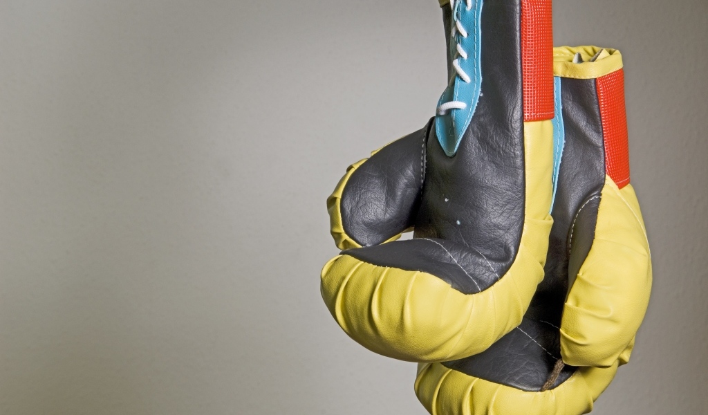 Боксерские перчатки на фоне серой стены 