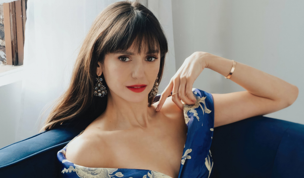 Милая девушка актриса Нина Добрев на диване