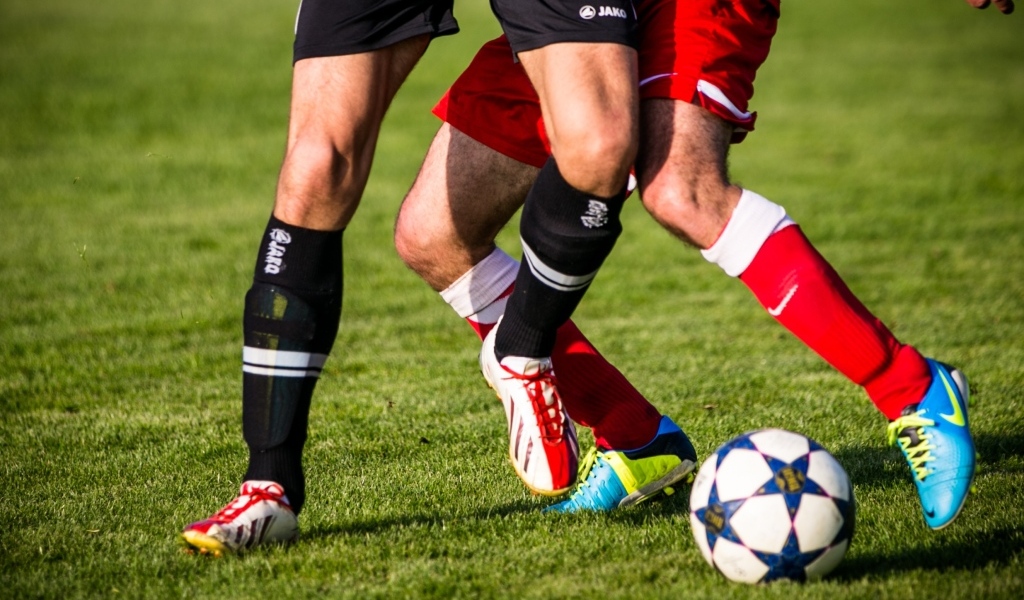 Футболисты играют в футбол на поле