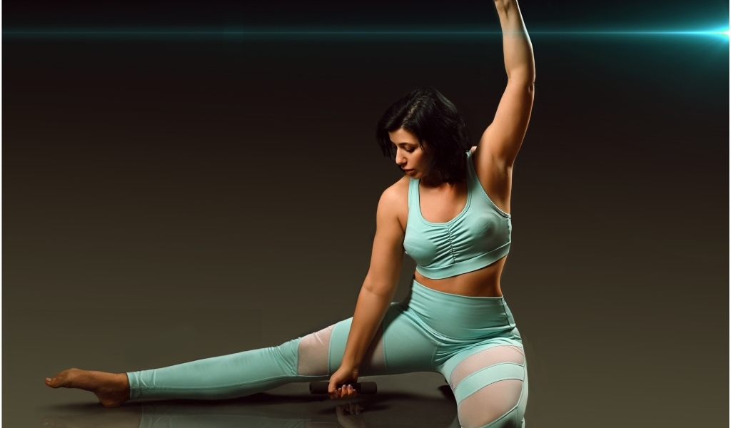 Девушка занимается фитнесом с гантелями