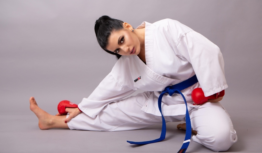 Девушка в белой спортивной форме на сером фоне