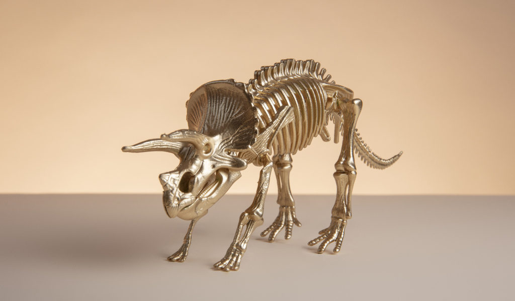 Золотой скелет динозавра на коричневом фоне