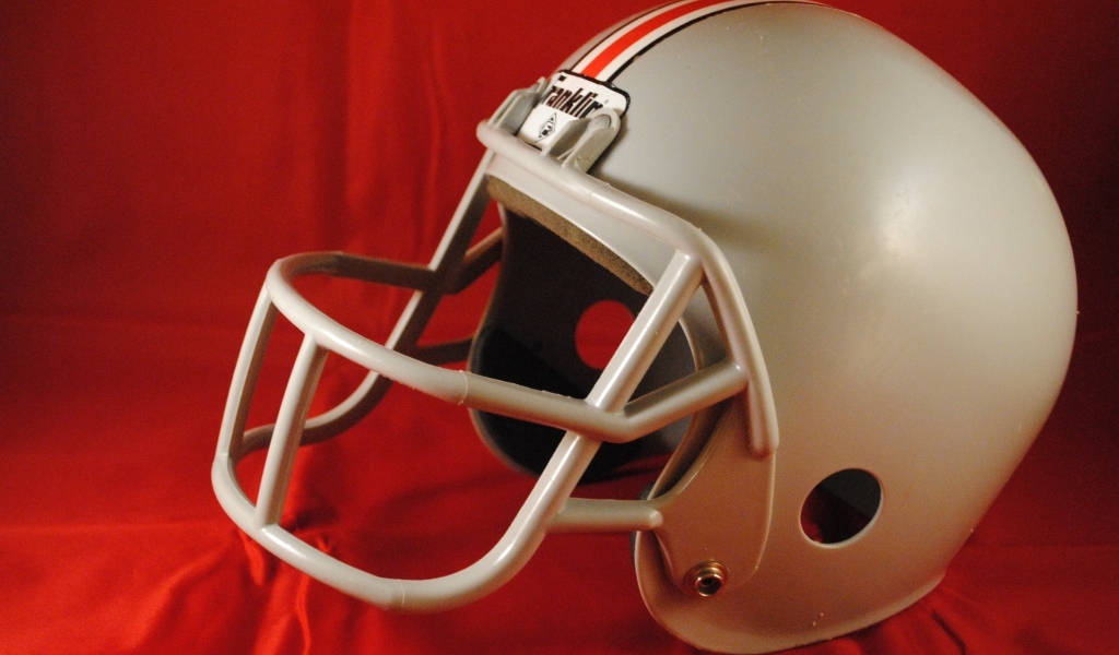 Шлем для игры в американский футбол на красном фоне