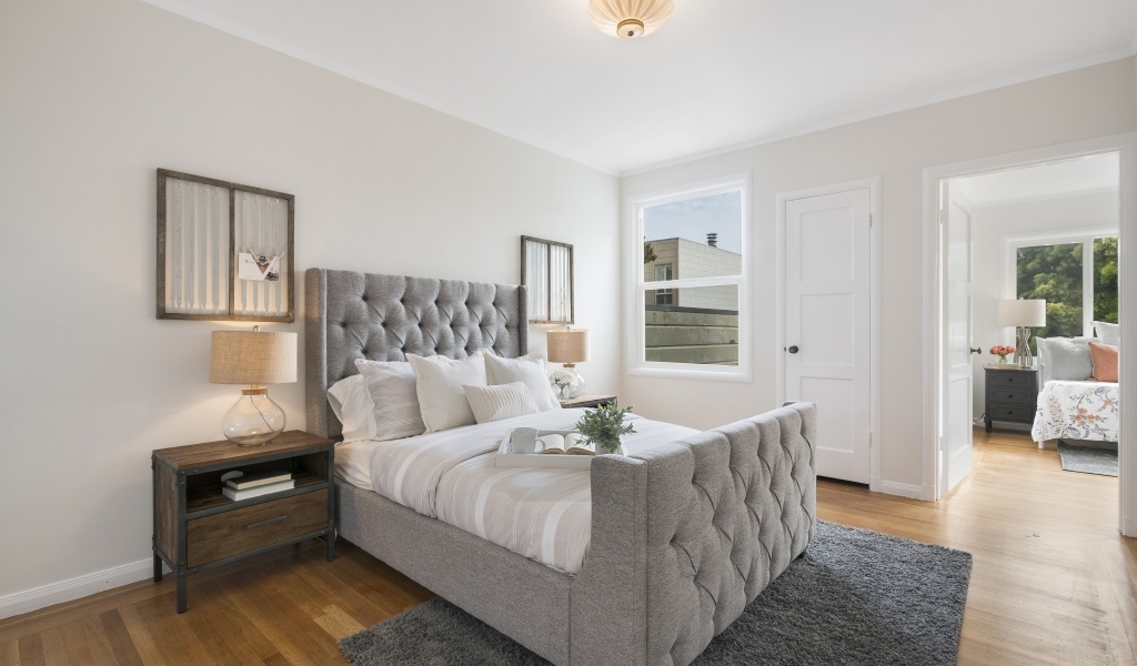 Высокая серая кровать в спальной комнате