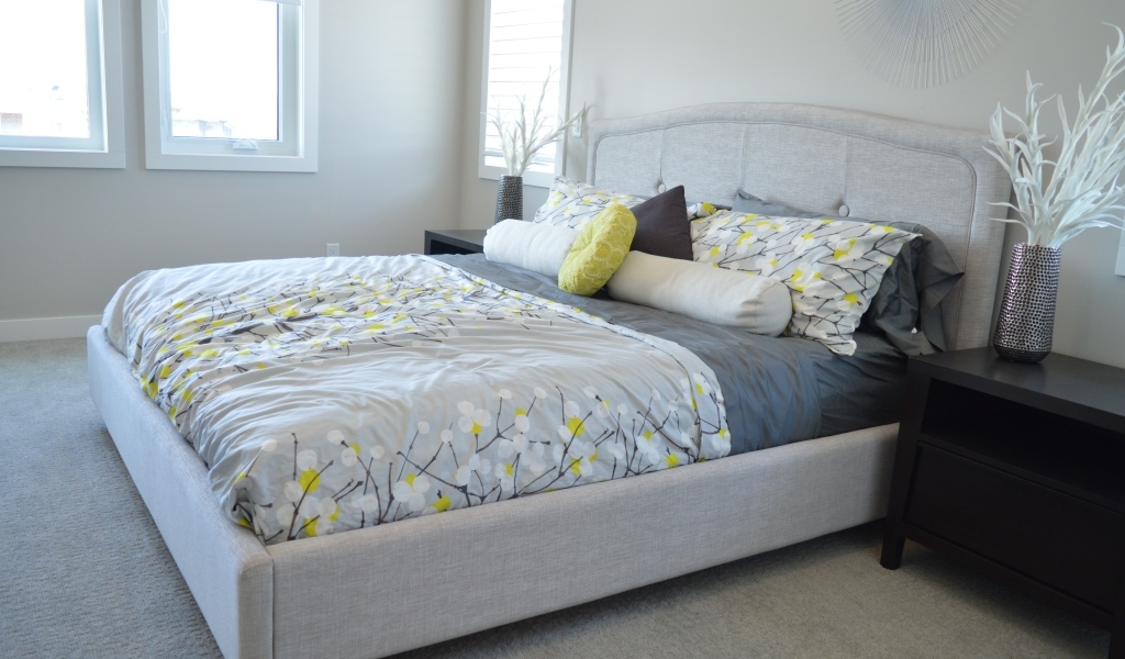 Большая мягкая кровать в серой спальне